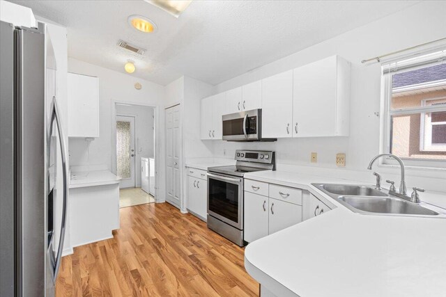 kitchen with white cabinets, decorative light fixtures, and wood-type flooring