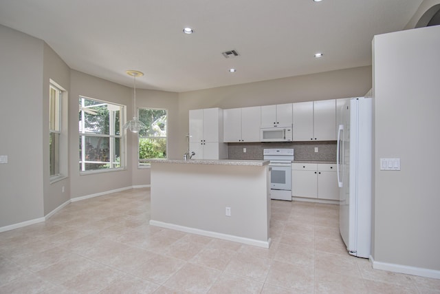 11481 Kanapali Ln, Boynton Beach, FL 33437 - kitchen with white appliances, light countertops, tasteful backsplash, a center island, and white cabinetry