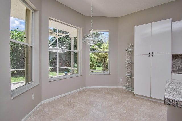 11481 Kanapali Ln, Boynton Beach, FL 33437 - unfurnished dining area with plenty of natural light, light tile patterned floors, baseboards, and a chandelier