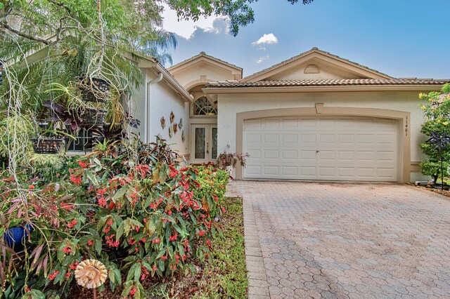 11481 Kanapali Ln, Boynton Beach, FL 33437 - mediterranean / spanish-style home featuring stucco siding, decorative driveway, an attached garage, and a tile roof