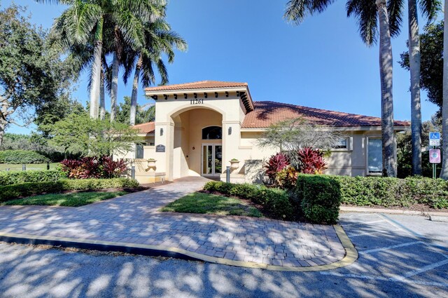 11481 Kanapali Ln, Boynton Beach, FL 33437 - mediterranean / spanish-style home with french doors, stucco siding, a tiled roof, and uncovered parking