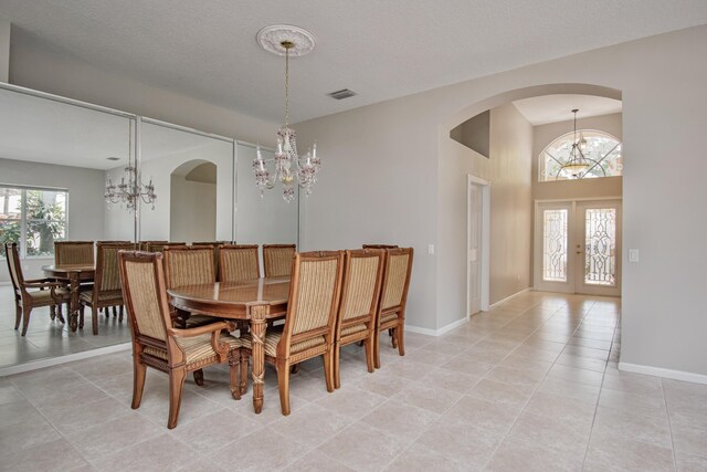 11481 Kanapali Ln, Boynton Beach, FL 33437 - dining room with a chandelier, arched walkways, french doors, and light tile patterned floors
