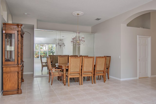 11481 Kanapali Ln, Boynton Beach, FL 33437 - dining space featuring light tile patterned floors, baseboards, a chandelier, and arched walkways