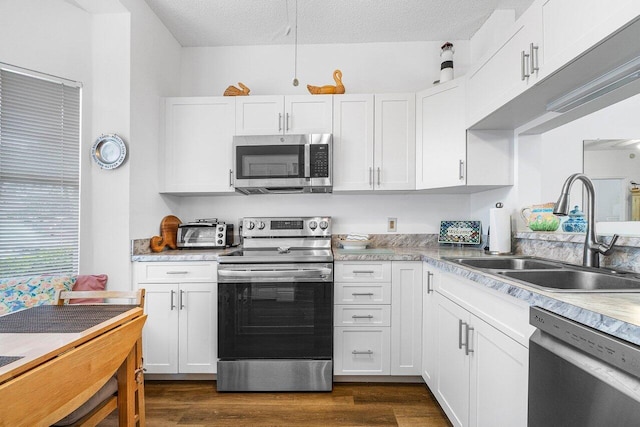 kitchen featuring white cabinetry, sink, appliances with stainless steel finishes, a textured ceiling, and dark hardwood / wood-style flooring