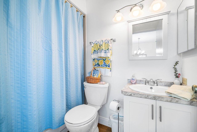 bathroom with toilet, vanity, a chandelier, and curtained shower