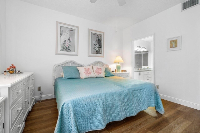 bedroom with ceiling fan, connected bathroom, a textured ceiling, and dark hardwood / wood-style flooring