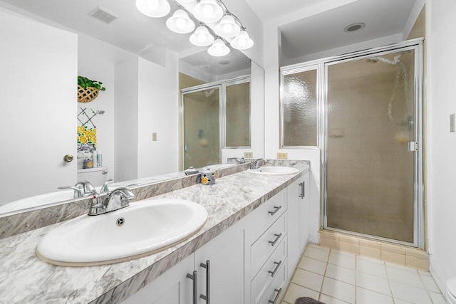 bathroom with walk in shower, vanity, and tile patterned floors