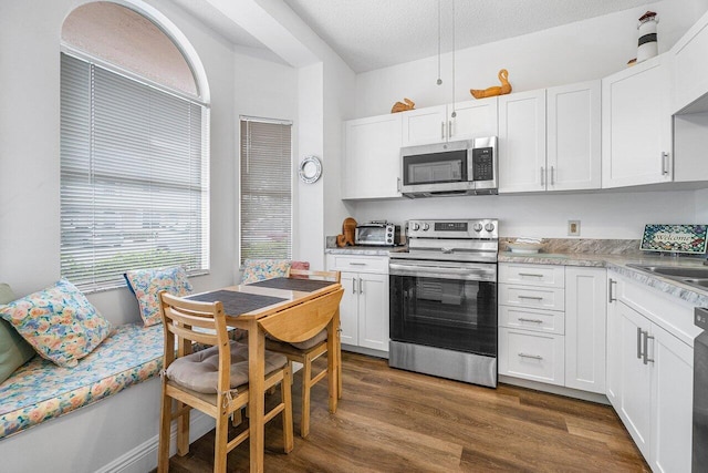 kitchen featuring stainless steel appliances, a textured ceiling, sink, white cabinets, and dark wood-type flooring