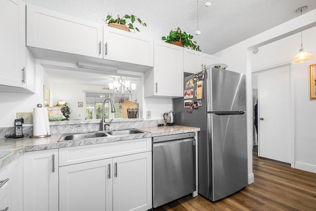 kitchen with stainless steel appliances, a textured ceiling, dark hardwood / wood-style floors, sink, and white cabinets