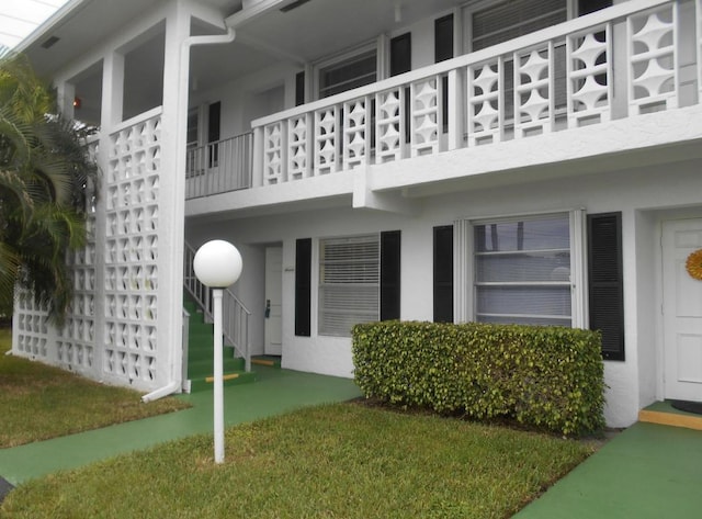 exterior space featuring a lawn and a balcony