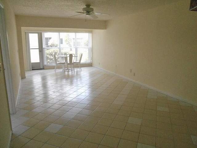 tiled spare room with ceiling fan and a textured ceiling