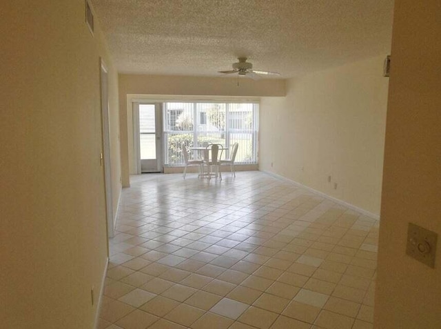 tiled spare room with ceiling fan and a textured ceiling