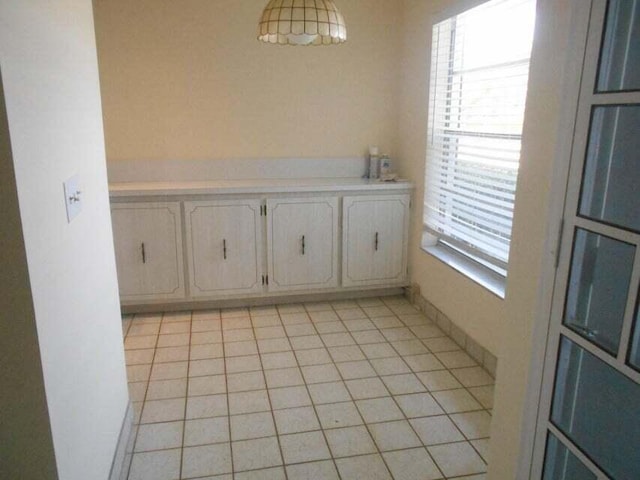 unfurnished dining area featuring light tile patterned flooring