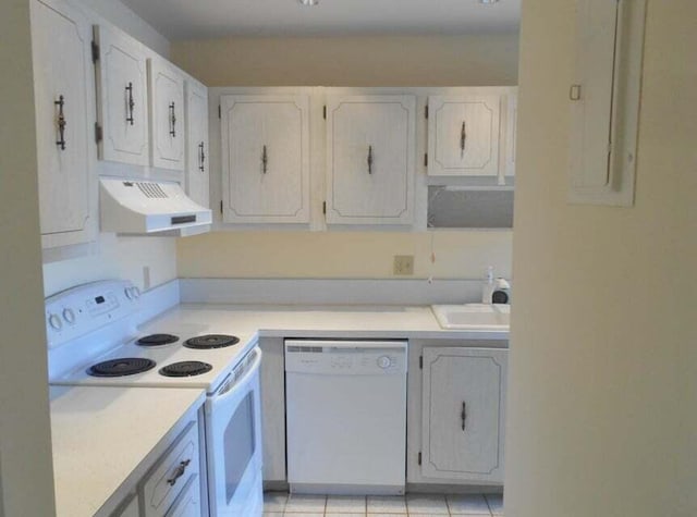 kitchen with electric panel, light tile patterned floors, white cabinetry, sink, and white appliances