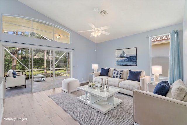 living room with ceiling fan, light hardwood / wood-style flooring, and high vaulted ceiling