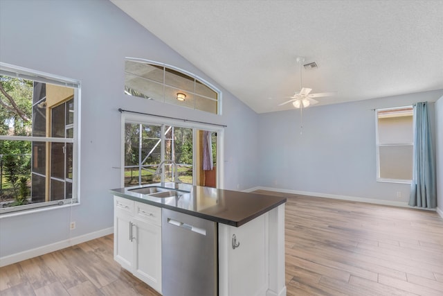 kitchen featuring a textured ceiling, sink, stainless steel dishwasher, white cabinetry, and light hardwood / wood-style flooring