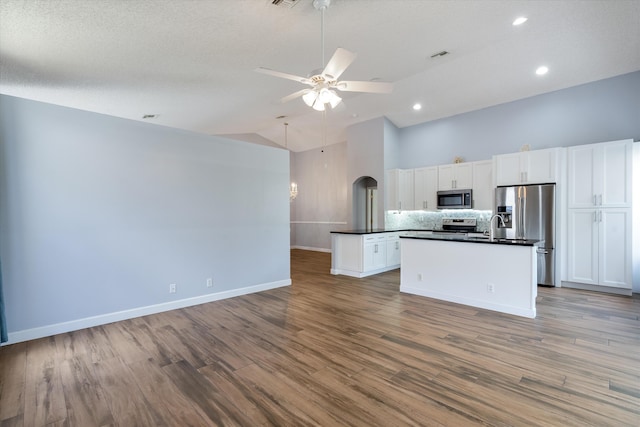 kitchen with stainless steel appliances, an island with sink, light hardwood / wood-style floors, white cabinets, and ceiling fan