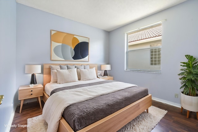 bedroom with dark hardwood / wood-style floors