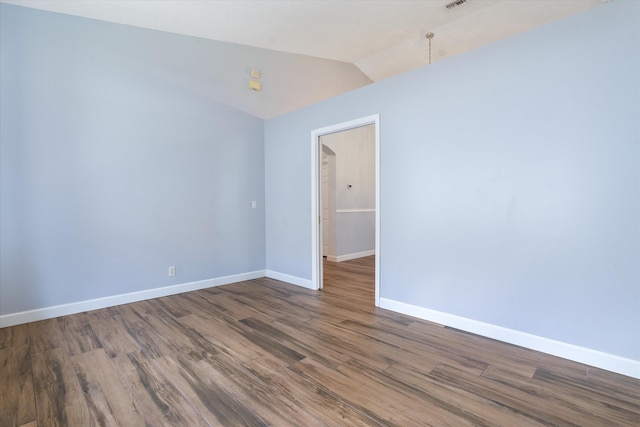 spare room with dark hardwood / wood-style floors and lofted ceiling