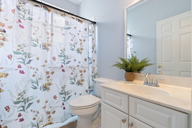 bathroom featuring toilet, vanity, and curtained shower