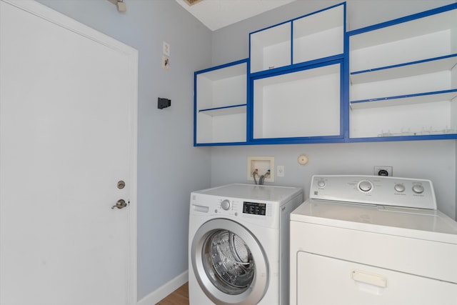 laundry room with wood-type flooring and washer and dryer