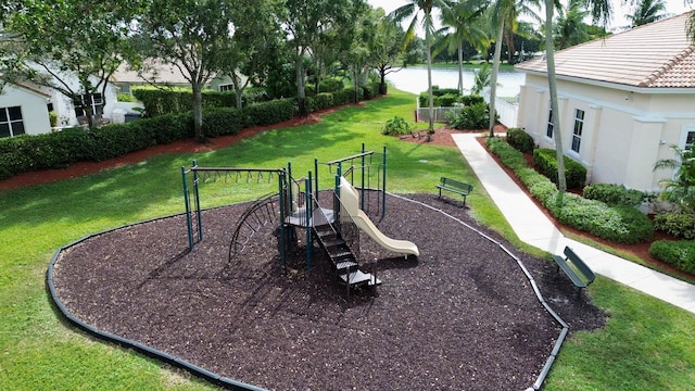 view of jungle gym featuring a lawn and a water view