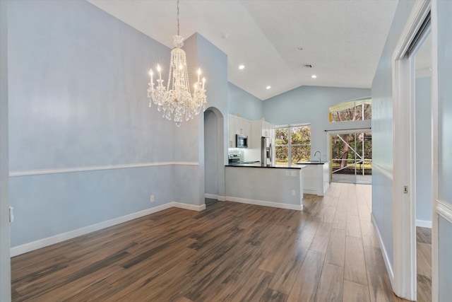 interior space with high vaulted ceiling, dark wood-type flooring, sink, and a notable chandelier