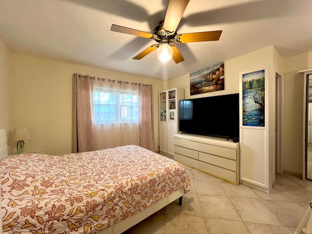 bedroom featuring light tile patterned floors, a textured ceiling, and ceiling fan