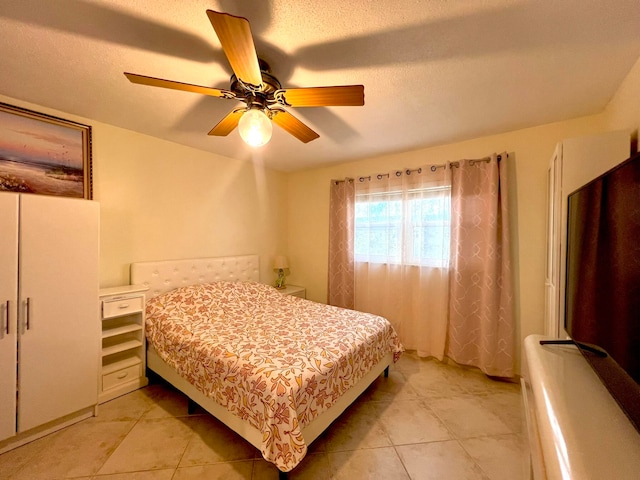 tiled bedroom featuring a textured ceiling and ceiling fan