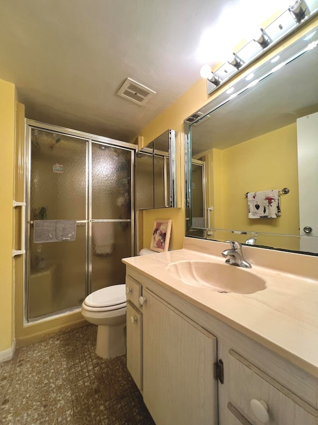 bathroom with vanity, a shower with shower door, and toilet