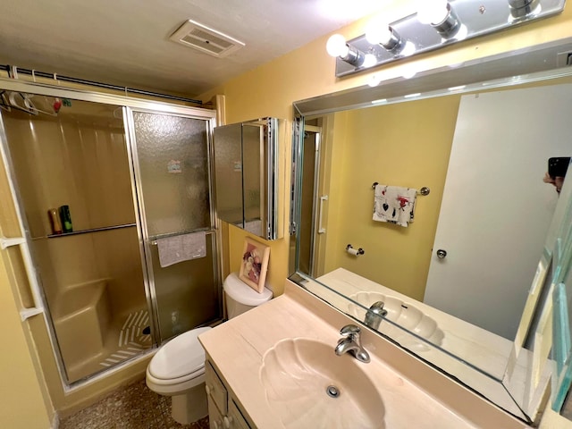 bathroom featuring vanity, toilet, and an enclosed shower