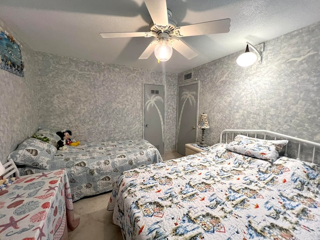 bedroom with ceiling fan and a textured ceiling