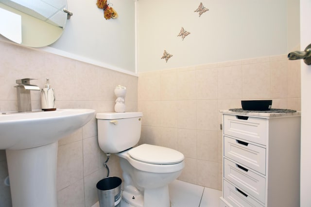 bathroom featuring tile patterned floors, tile walls, and toilet