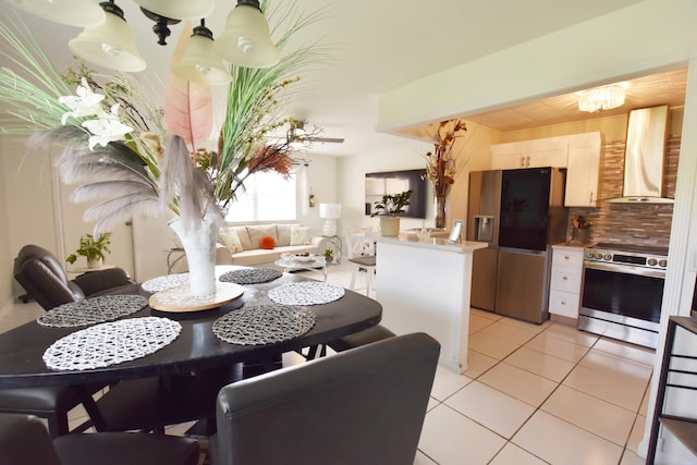 tiled dining area with ceiling fan with notable chandelier