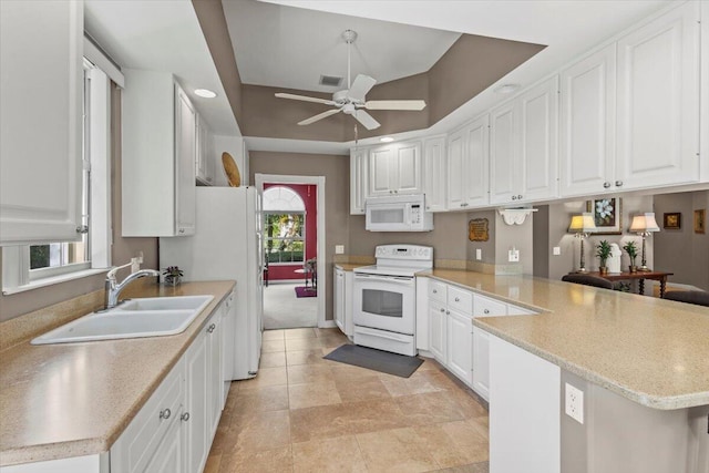 kitchen with white cabinetry, kitchen peninsula, and white appliances