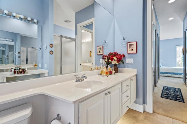 bathroom with vanity, toilet, tile patterned floors, and a shower with door