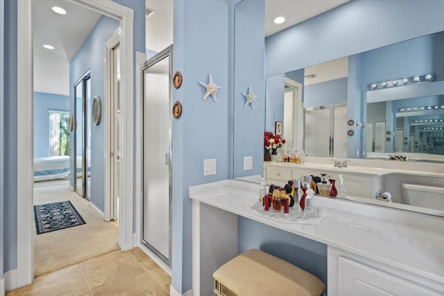 bathroom featuring a shower with door, vanity, and tile patterned floors