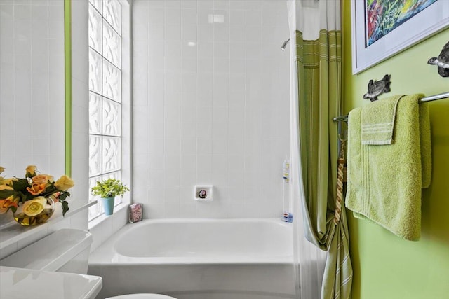 bathroom with shower / bath combination with curtain and toilet