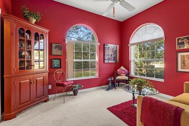 sitting room featuring light colored carpet and ceiling fan