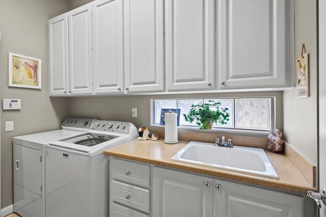 washroom featuring sink, independent washer and dryer, and cabinets