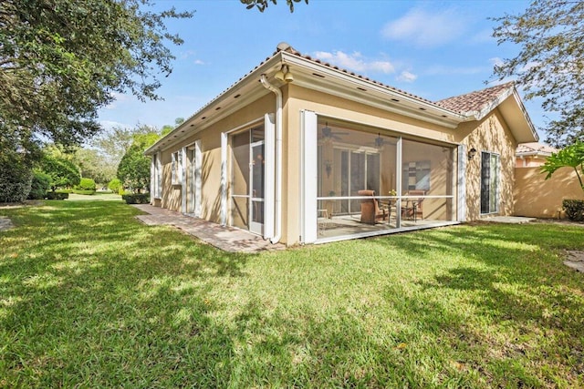 back of house with a sunroom and a lawn