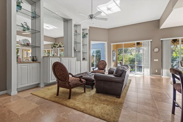 tiled living room with ceiling fan and built in shelves