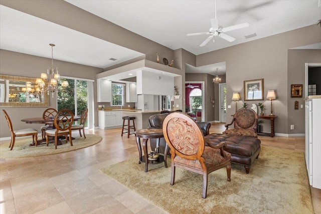 tiled living room featuring ceiling fan with notable chandelier and plenty of natural light