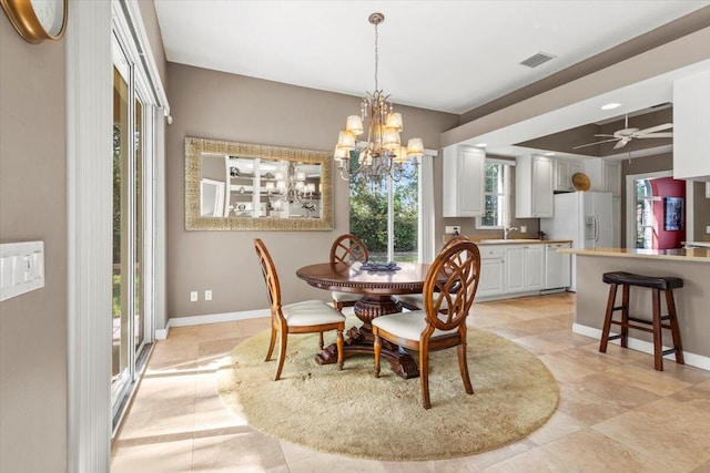 dining room with sink and ceiling fan with notable chandelier