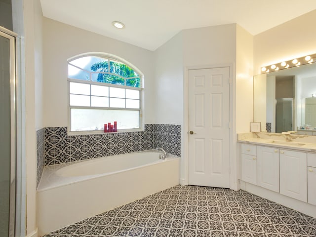 bathroom featuring vanity and independent shower and bath