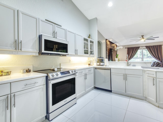 kitchen with white cabinetry, light tile patterned flooring, stainless steel appliances, and vaulted ceiling