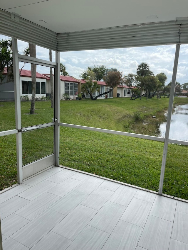 unfurnished sunroom with a water view