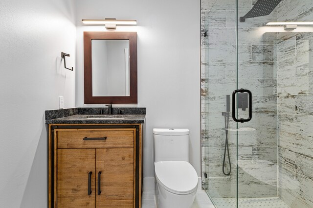 bathroom with a shower with door, vanity, and toilet