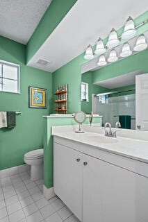 bathroom with tile patterned floors, vanity, toilet, and a shower with door