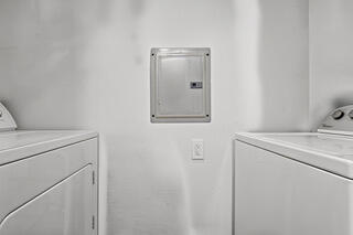 clothes washing area featuring separate washer and dryer and electric panel